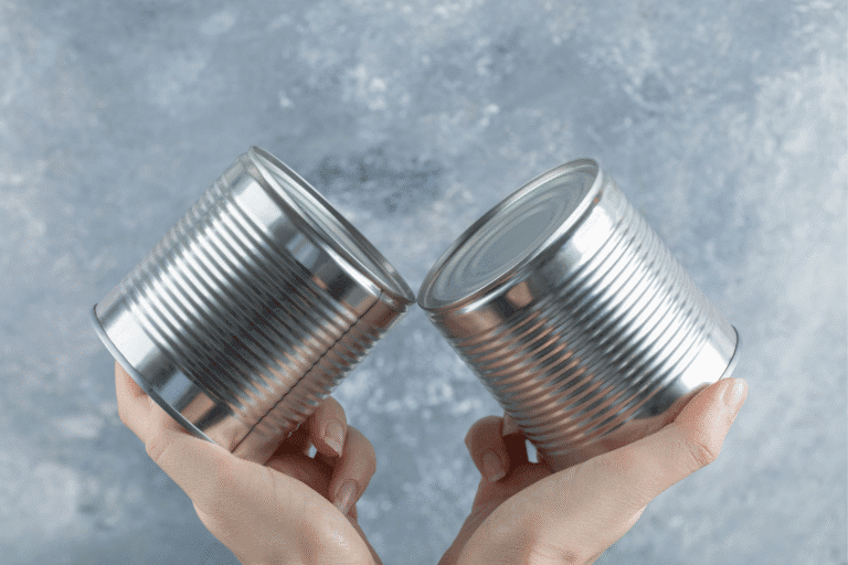 Dłonie, w których trzymane są konserwy