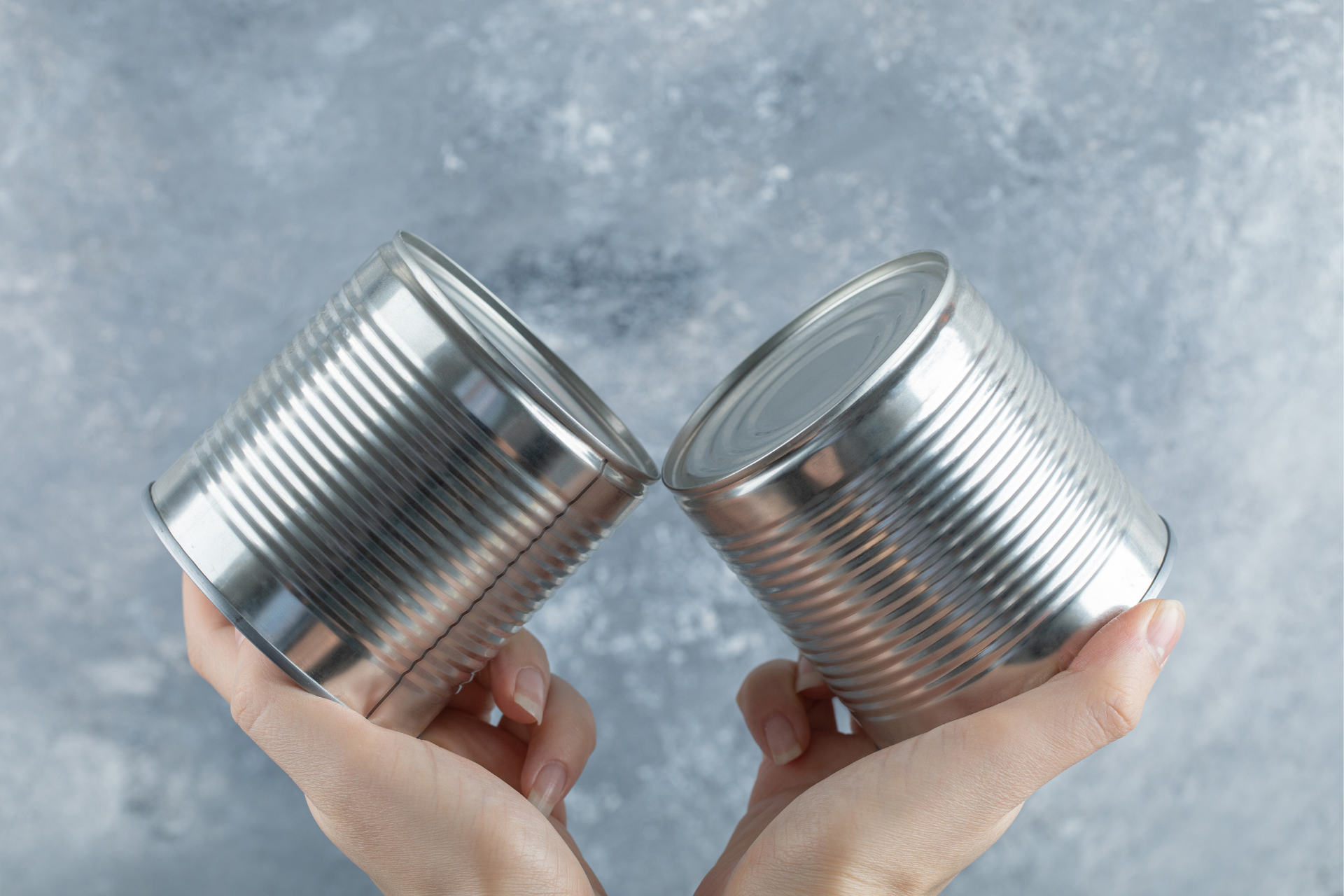 Dłonie, w których trzymane są konserwy